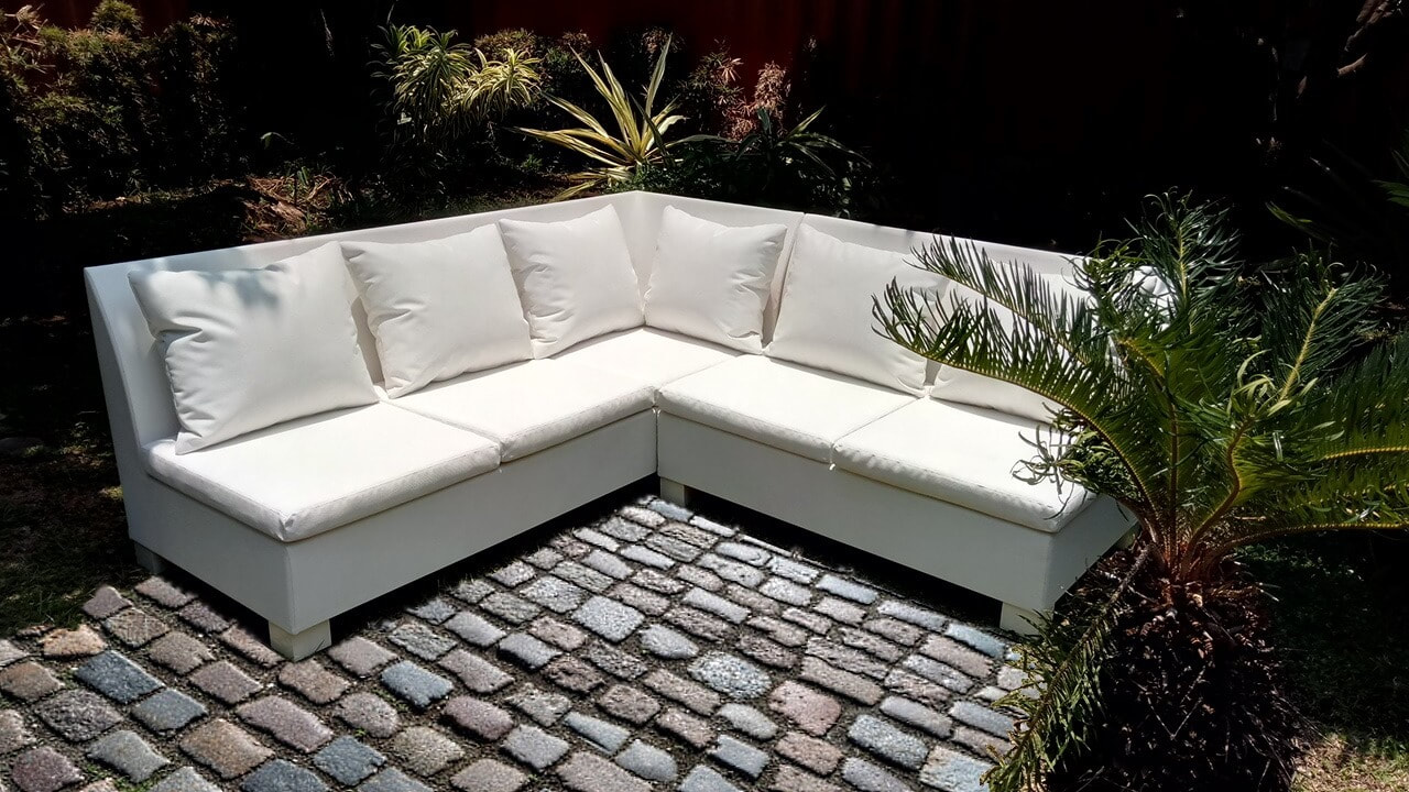 Corner sofa in garden of Malaga on stone floor and tropical garden 