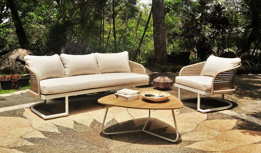 Sofa and club armchair with weaved rope and teak table in a tropical garden in Malaga, Andalusia